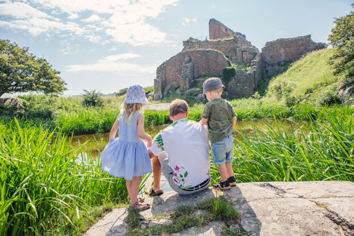 Vater mit zwei Kindern an einem kleinen Teich unterhalb der Burgruine Hammershus auf Bornholm