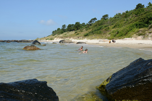 Badende Kinder im klaren, ruhigen Wasser am Galløkken Strand südlich von Rønne