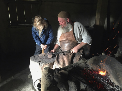 Ein Kind versucht sich im Freilichtmuseum Odins Odense im Schmieden