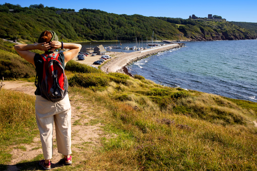 Frau mit Rucksack wandert im Naturgebiet Hammeren auf Nordbornholm