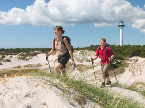 Ein Paar mit Walkingstöcken wandert durch die Dünen von Dueodde