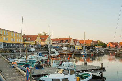 Blick auf den Hafen von Svaneke mit kleinen Segelbooten und gelbgetünchten alten Häusern
