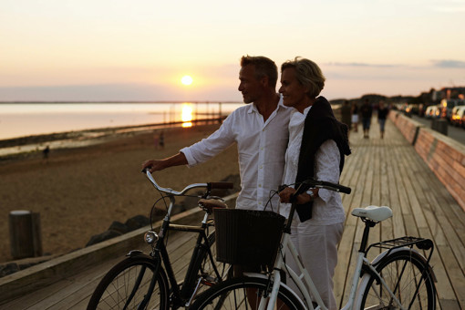 Paar, das den Sonnenuntergang am Wattenmeer an der Nordsee betrachtet