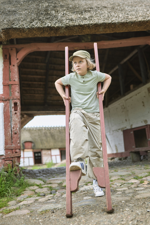 Junge auf Stelzen