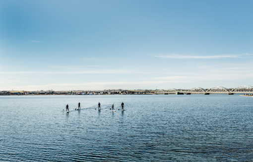 Stand Up Paddle Surfer auf den Gewässern des Limfjords in der Nähe der Vilsundbrücke