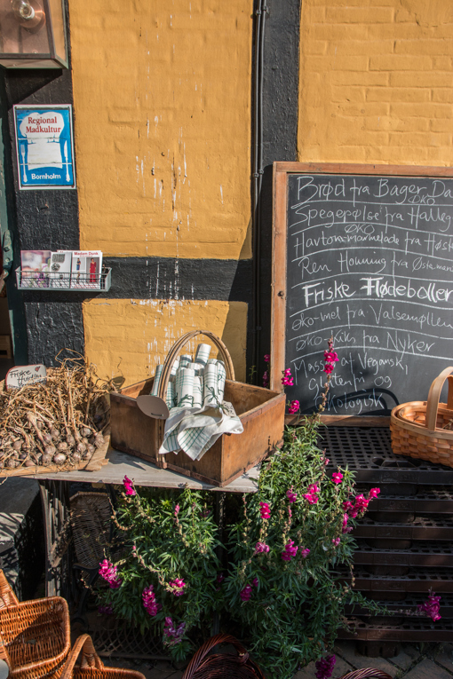 Blumen zieren einen kleinen Verkaufsstand in Aarkirkeby auf Bornholm