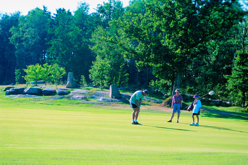 Golfer mit zwei Jungen auf einem Bornholmer Golfplatz