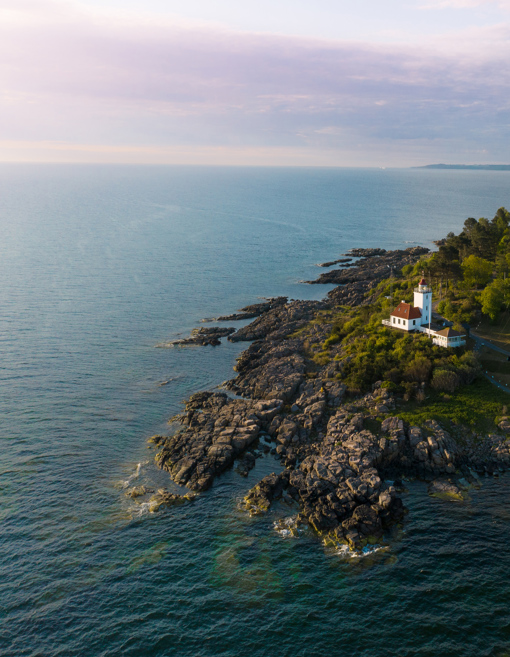 Der Leuchtturm Hammerodde Fyr thront hoch über der Felsenküste im Naturgebiet Hammerknuden